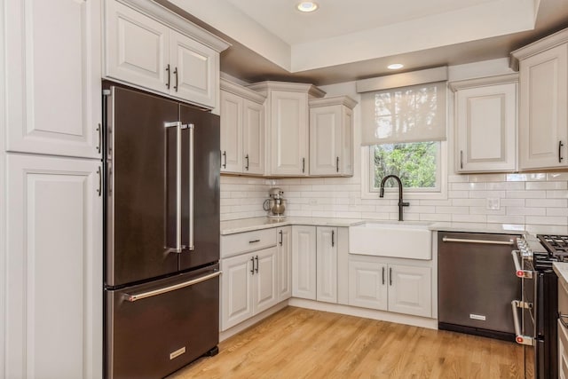835 W 37th St Unit A, Chicago, IL 60609 - kitchen with appliances with stainless steel finishes, backsplash, recessed lighting, light stone counters, and light wood-style flooring