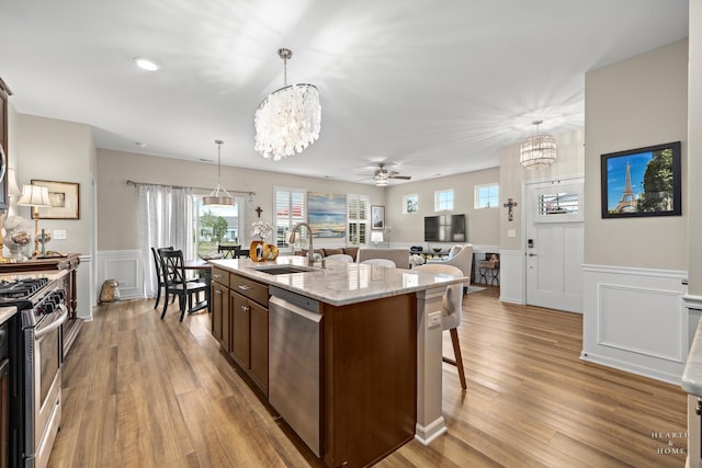 1106 Crestview Ln, Pingree Grove, IL 60140 - kitchen with appliances with stainless steel finishes, a chandelier, a ceiling fan, a breakfast bar area, and a wainscoted wall