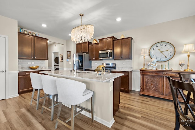 1106 Crestview Ln, Pingree Grove, IL 60140 - kitchen featuring stainless steel appliances, backsplash, a kitchen bar, light wood-style flooring, and recessed lighting