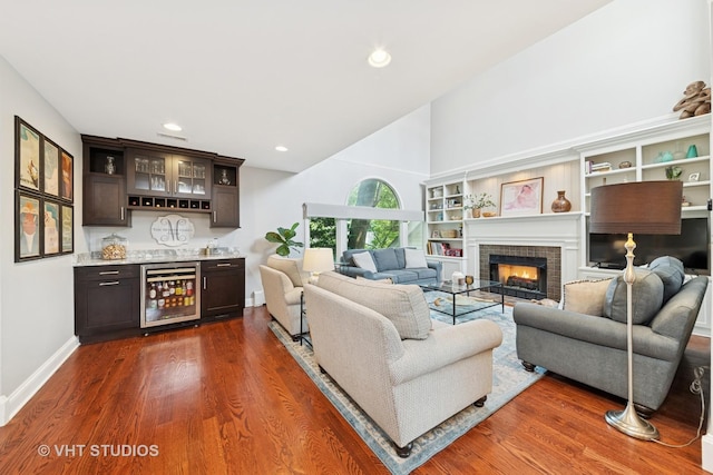 571 N Main St, Glen Ellyn, IL 60137 - living area featuring wine cooler, bar area, dark wood-style flooring, high vaulted ceiling, and a lit fireplace