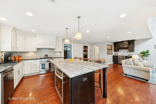 571 N Main St, Glen Ellyn, IL 60137 - kitchen with appliances with stainless steel finishes, custom range hood, a breakfast bar, white cabinets, and recessed lighting
