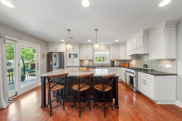 571 N Main St, Glen Ellyn, IL 60137 - kitchen with appliances with stainless steel finishes, dark wood-type flooring, white cabinetry, tasteful backsplash, and a kitchen island