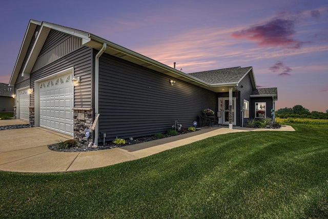 3872 Stadium St, Portage, IN 46368 - property exterior at dusk featuring an attached garage, a yard, driveway, and a shingled roof