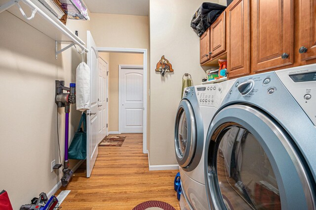 3872 Stadium St, Portage, IN 46368 - laundry area with washer and clothes dryer, light wood-style floors, and cabinet space