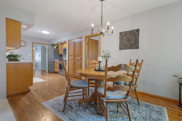 912 Eden Dr, Schaumburg, IL 60195 - dining space featuring light wood-style floors and a chandelier