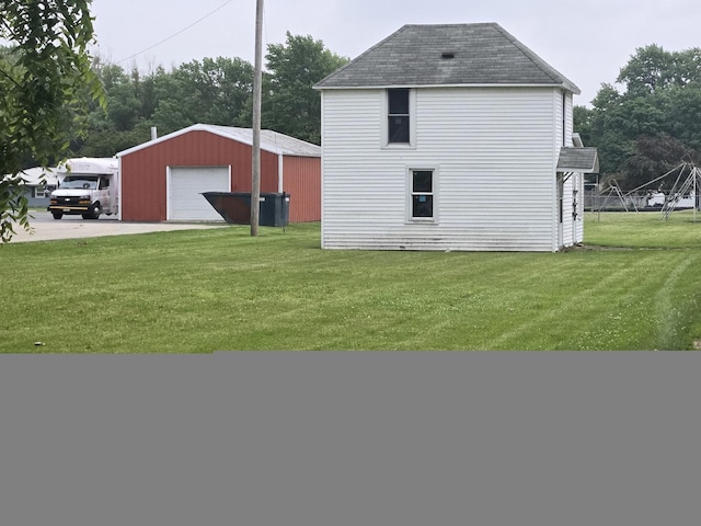 101 Vine St, Ludlow, IL 60949 - view of home's exterior featuring a garage, roof with shingles, a yard, and an outbuilding