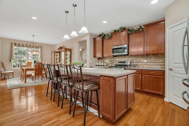 739 Pleasant Dr, Shorewood, IL 60404 - kitchen with stainless steel appliances, light wood-style flooring, brown cabinetry, light countertops, and recessed lighting