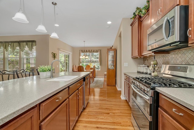 739 Pleasant Dr, Shorewood, IL 60404 - kitchen featuring stainless steel appliances, light wood-type flooring, light countertops, backsplash, and pendant lighting