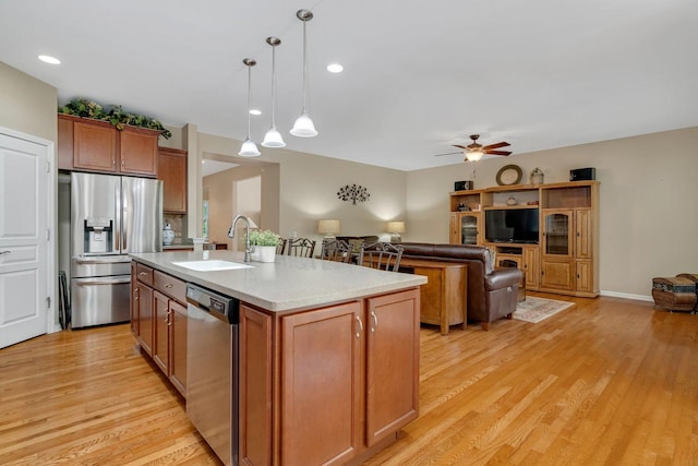 739 Pleasant Dr, Shorewood, IL 60404 - kitchen featuring appliances with stainless steel finishes, light wood-style flooring, brown cabinets, a ceiling fan, and decorative light fixtures