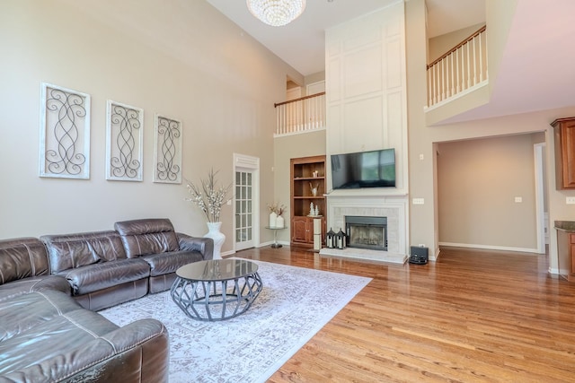 105 Black Hill Dr, Streamwood, IL 60107 - living room featuring a high ceiling, light wood finished floors, a fireplace, and a chandelier