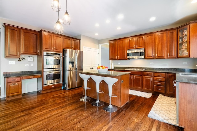 105 Black Hill Dr, Streamwood, IL 60107 - kitchen featuring stainless steel appliances, dark wood-style flooring, glass insert cabinets, a kitchen island, and a breakfast bar