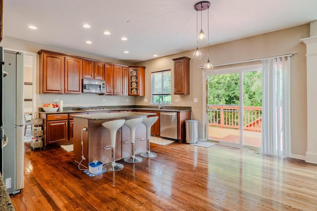 105 Black Hill Dr, Streamwood, IL 60107 - kitchen with stainless steel appliances, a kitchen island, dark wood-style flooring, a breakfast bar area, and glass insert cabinets