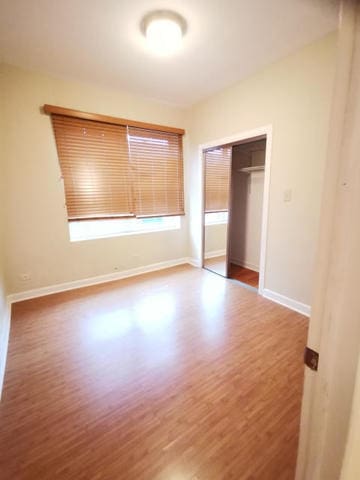 2121 N Saint Louis Ave Unit 3S, Chicago, IL 60647 - unfurnished bedroom featuring wood finished floors and a closet