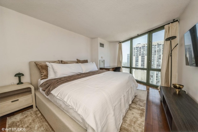 111 W Maple St Unit 2803, Chicago, IL 60610 - bedroom with wood finished floors, a wall of windows, and a textured ceiling
