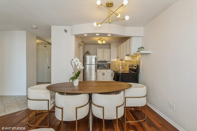 111 W Maple St Unit 2803, Chicago, IL 60610 - dining space featuring a textured ceiling, a chandelier, and dark wood-type flooring