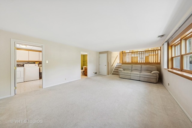 7769 Danbury Dr, Darien, IL 60561 - living room featuring separate washer and dryer, light colored carpet, and stairway