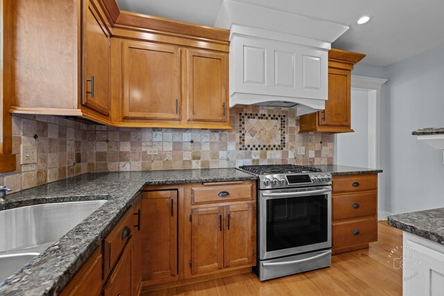 342 Dilorenzo Dr, Naperville, IL 60565 - kitchen featuring stainless steel range with gas stovetop, brown cabinets, light wood-style flooring, and dark stone counters