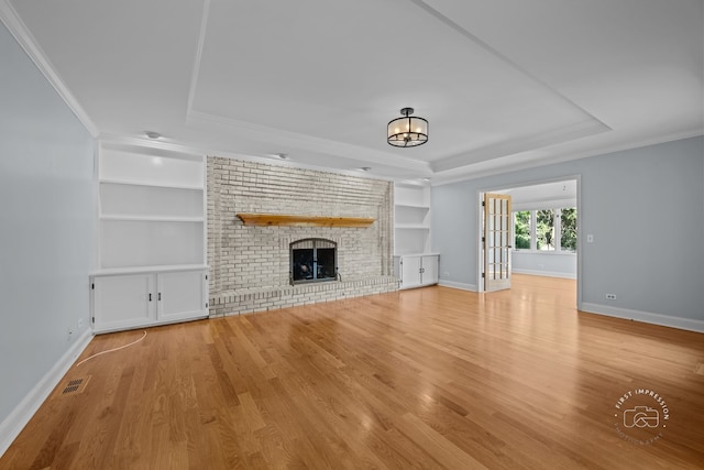 342 Dilorenzo Dr, Naperville, IL 60565 - unfurnished living room featuring a raised ceiling, built in shelves, light wood-style floors, a fireplace, and crown molding