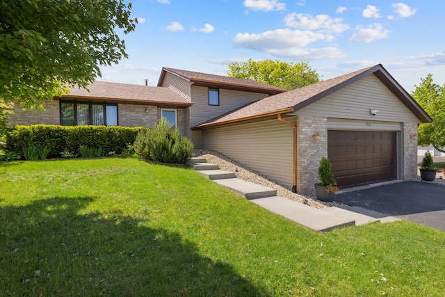 5555 Raspberry Trl, Rockford, IL 61114 - tri-level home featuring a garage, asphalt driveway, a front yard, brick siding, and a shingled roof