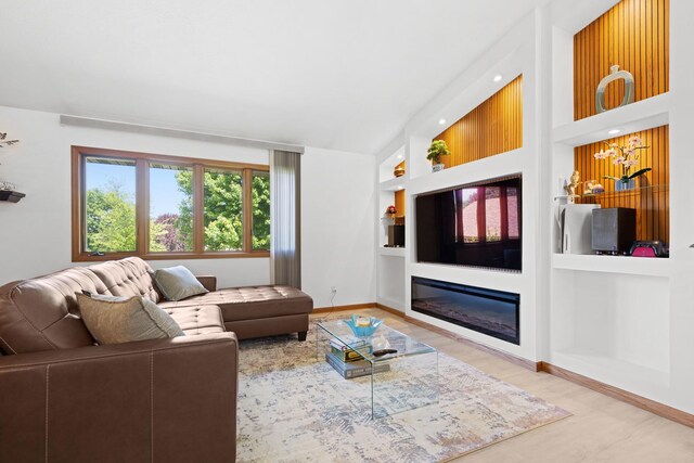 5555 Raspberry Trl, Rockford, IL 61114 - living area featuring built in shelves, a glass covered fireplace, and wood finished floors