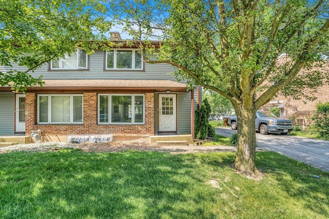 17 Michael Rd, Park Forest, IL 60466 - view of front facade featuring brick siding, a front lawn, a chimney, a shingled roof, and asphalt driveway