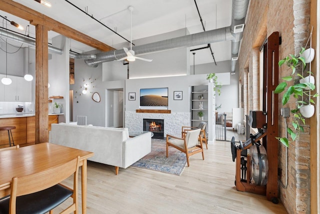 2511 W Moffat St Unit 501, Chicago, IL 60647 - living area featuring a towering ceiling, ceiling fan, a glass covered fireplace, and light wood-style floors
