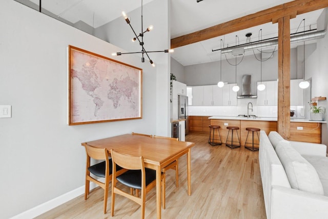 2511 W Moffat St Unit 501, Chicago, IL 60647 - dining space with light wood-type flooring, a chandelier, a towering ceiling, and wine cooler