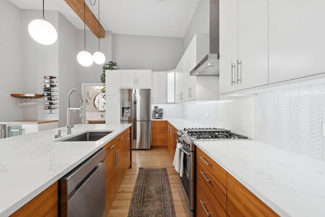 2511 W Moffat St Unit 501, Chicago, IL 60647 - kitchen featuring appliances with stainless steel finishes, wall chimney range hood, light wood-style floors, tasteful backsplash, and light stone countertops