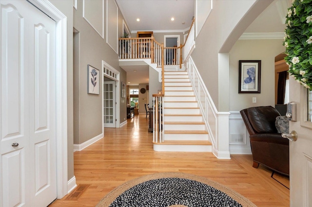 601 W Crockett Ave, Elmhurst, IL 60126 - entrance foyer featuring arched walkways, crown molding, light wood-style floors, and stairs