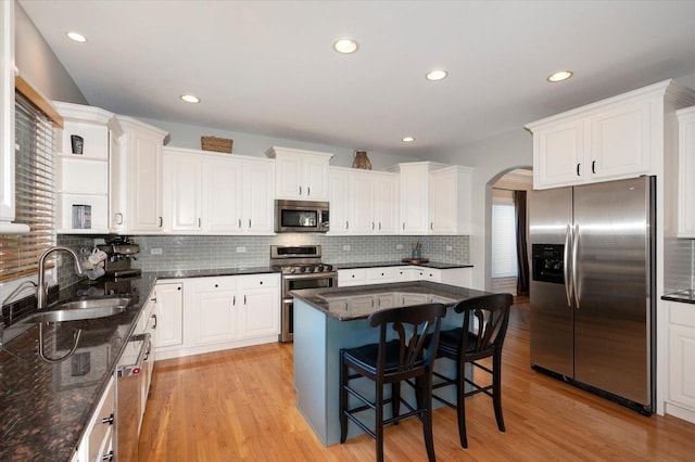 601 W Crockett Ave, Elmhurst, IL 60126 - kitchen featuring stainless steel appliances, arched walkways, light wood-type flooring, white cabinetry, and recessed lighting