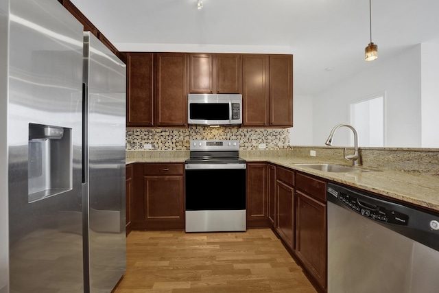 100 E 14th St Unit 2007, Chicago, IL 60605 - kitchen with appliances with stainless steel finishes, light stone countertops, light wood-style flooring, backsplash, and decorative light fixtures