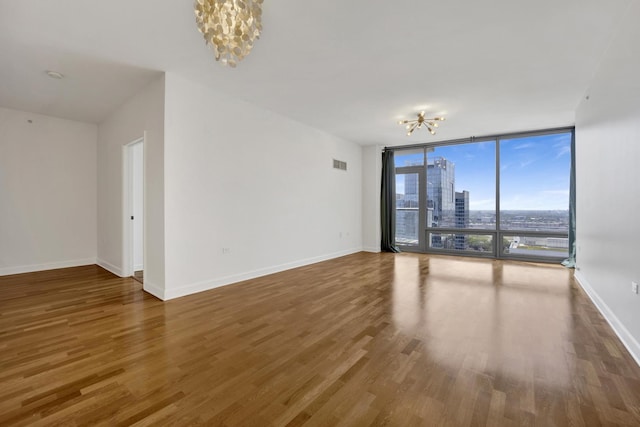 100 E 14th St Unit 2007, Chicago, IL 60605 - spare room with a chandelier, expansive windows, wood finished floors, and a view of city