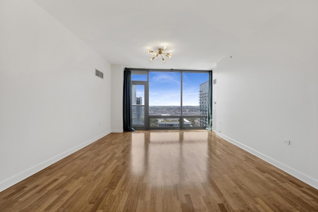 100 E 14th St Unit 2007, Chicago, IL 60605 - spare room featuring a wall of windows, wood finished floors, and a chandelier