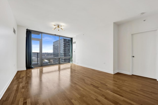 100 E 14th St Unit 2007, Chicago, IL 60605 - spare room with a wall of windows, wood finished floors, and a chandelier