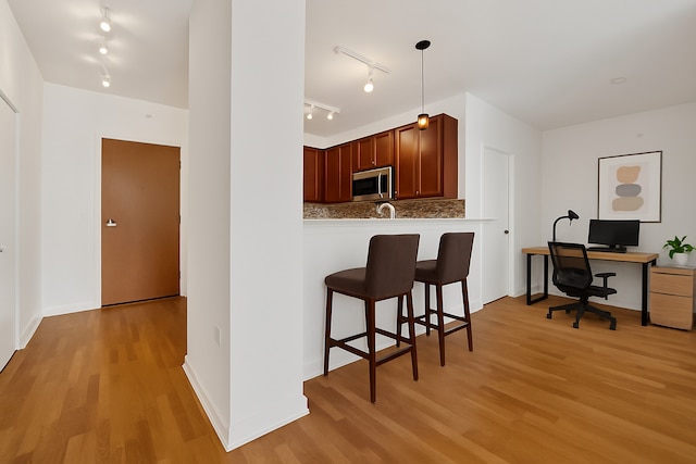 100 E 14th St Unit 2007, Chicago, IL 60605 - kitchen with track lighting, stainless steel microwave, a kitchen breakfast bar, and light wood finished floors