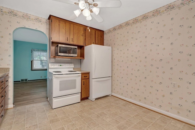 505 Douglas St, Morris, IL 60450 - kitchen with white appliances, wallpapered walls, a ceiling fan, brown cabinets, and light countertops