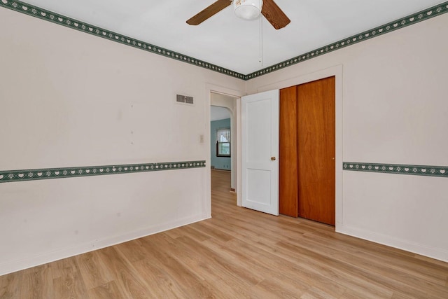 505 Douglas St, Morris, IL 60450 - empty room with light wood-style floors, arched walkways, and a ceiling fan