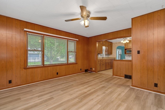 505 Douglas St, Morris, IL 60450 - unfurnished living room with a ceiling fan, light wood-style floors, and wooden walls