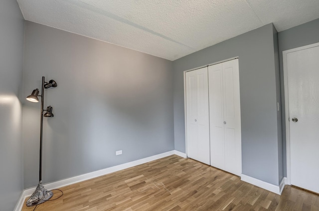 5550 Astor Ln Unit 214, Rolling Meadows, IL 60008 - unfurnished bedroom with wood finished floors, a closet, and a textured ceiling