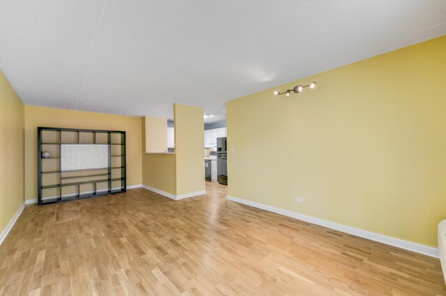 5550 Astor Ln Unit 214, Rolling Meadows, IL 60008 - unfurnished living room featuring light wood-style flooring and baseboards