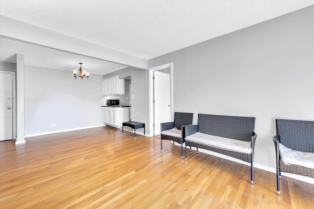 9205 Potter Rd Unit 1C, Des Plaines, IL 60016 - sitting room featuring a chandelier, light wood-type flooring, and a textured ceiling