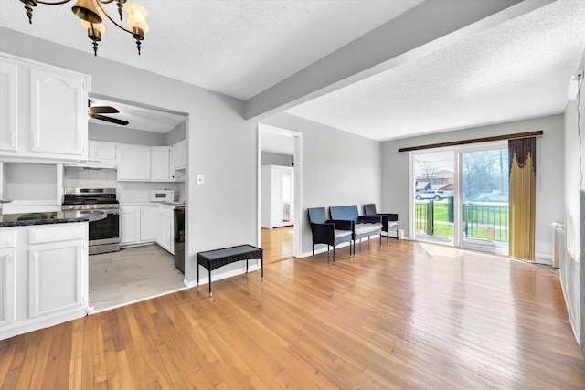 9205 Potter Rd Unit 1C, Des Plaines, IL 60016 - kitchen with gas stove, a textured ceiling, white cabinets, light wood-style floors, and a chandelier