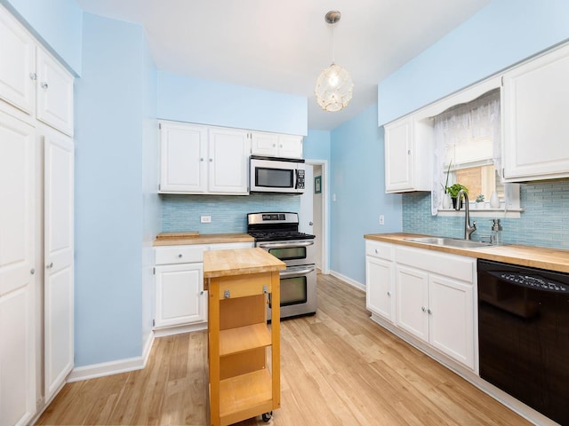4130 N Oketo Ave, Norridge, IL 60706 - kitchen featuring appliances with stainless steel finishes, wood counters, decorative backsplash, and light wood-style flooring