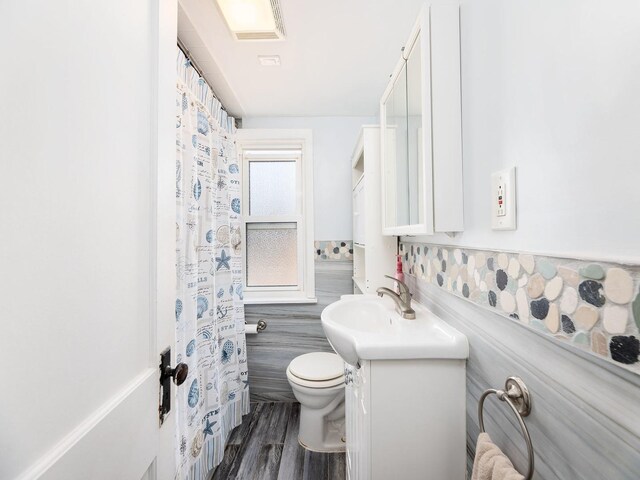 4130 N Oketo Ave, Norridge, IL 60706 - bathroom featuring vanity, tile walls, wood finished floors, and curtained shower