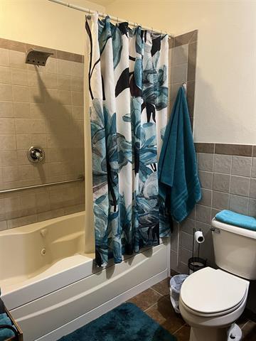 5918 Park Ridge Rd, Loves Park, IL 61111 - full bath featuring shower / bath combo with shower curtain, tile patterned flooring, tile walls, and wainscoting