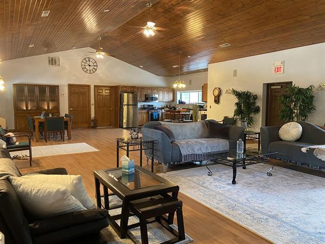 5918 Park Ridge Rd, Loves Park, IL 61111 - living area featuring a ceiling fan, light wood-style floors, wooden ceiling, high vaulted ceiling, and a chandelier