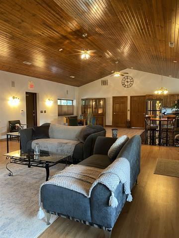 5918 Park Ridge Rd, Loves Park, IL 61111 - living room featuring ceiling fan, wood finished floors, vaulted ceiling, a chandelier, and wooden ceiling