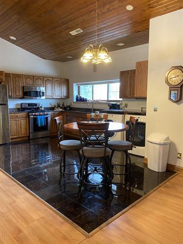 5918 Park Ridge Rd, Loves Park, IL 61111 - kitchen with appliances with stainless steel finishes, wooden ceiling, dark wood finished floors, a chandelier, and brown cabinets
