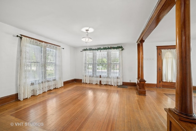 2S234 Harter Rd, Elburn, IL 60119 - unfurnished living room featuring ornate columns, hardwood / wood-style flooring, and plenty of natural light