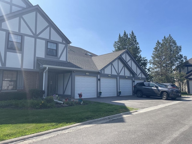 468 Elizabeth Dr Unit 17B, Wood Dale, IL 60191 - view of side of property with a shingled roof, an attached garage, a lawn, asphalt driveway, and brick siding
